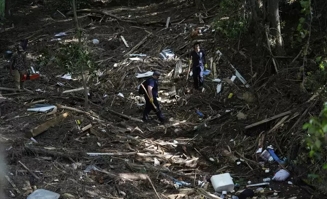 Search and rescue teams from Kerrville Fire Department search through debris after flooding near the banks of the Guadalupe River in Kerrville, Texas on Tuesday, July 8, 2025. (AP Photo/Ashley Landis)