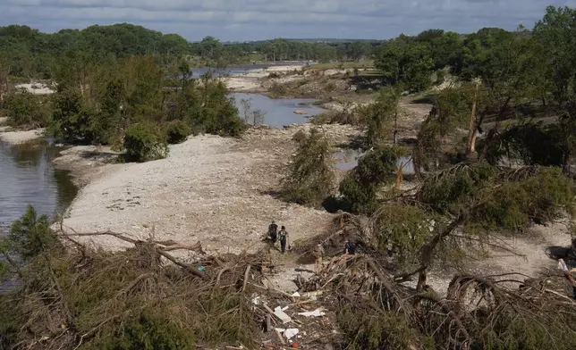 Search and rescue teams from Kerrville Fire Department walk past debris after flooding near the banks of the Guadalupe River in Kerrville, Texas on Tuesday, July 8, 2025. (AP Photo/Ashley Landis)