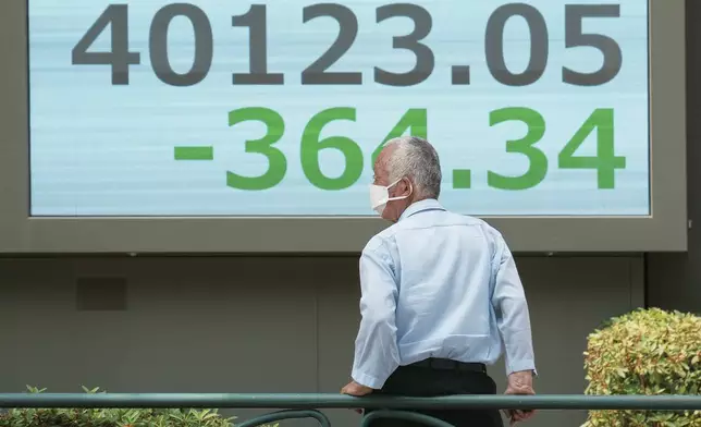 A person looks at an electronic stock board showing Japan's Nikkei index at a securities firm Tuesday, July 1, 2025, in Tokyo. (AP Photo/Eugene Hoshiko)