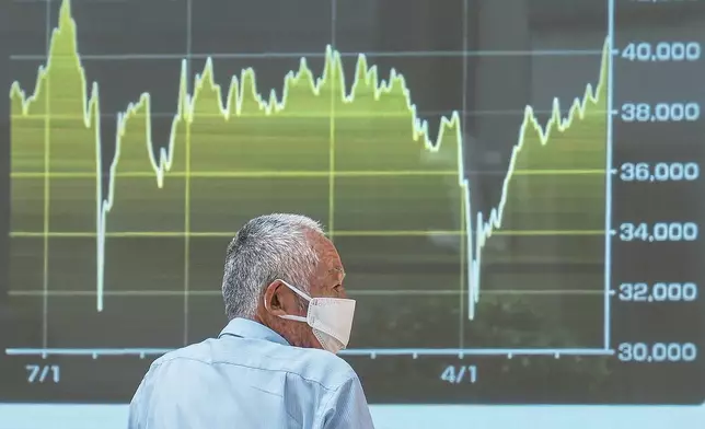 A person looks at an electronic stock board showing Japan's Nikkei index at a securities firm Tuesday, July 1, 2025, in Tokyo. (AP Photo/Eugene Hoshiko)