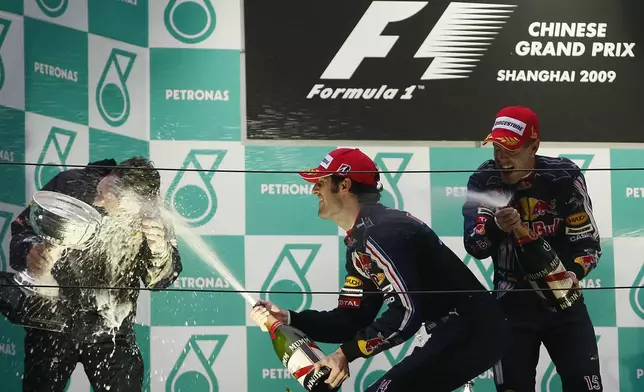 FILE - Red Bull Formula One drivers Sebastian Vettel of Germany, right, and Mark Webber of Australia, center, spray team Sporting Director Christian Horner after Vettel won the Chinese Formula One Grand Prix, and Webber finished second, at the Shanghai International Circuit in Shanghai, China, April 19, 2009.(AP Photo/Eugene Hoshiko, File)