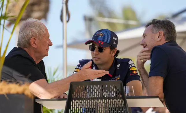 FILE - Red Bull team principal Christian Horner, right, chats with Red Bull driver Sergio Perez of Mexico, center, and Helmut Marko, director of the Red Bull Formula One teams, left, at the pits during Formula One pre season test at the Bahrain International Circuit in Sakhir, Bahrain, Feb. 21, 2024. (AP Photo/Darko Bandic, File)