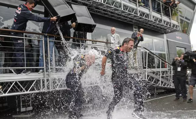 FILE - Red Bull team members dump buckets of ice water on Technical Chief Adrian Newey, left, and Team Chief Christian Horner at the Spa-Francorchamps circuit in Belgium for the "ice bucket challenge", Aug. 23, 2014. (AP Photo/Yves Logghe, File)