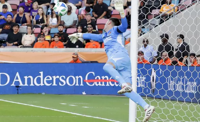 Houston Dynamo goalkeeper Jonathan Bond knocks away a shot on goal from the corner kick by the Vancouver Whitecaps during the first half of an MLS soccer match, Wednesday, July 16, 2025, in Houston. (AP Photo/Michael Wyke)