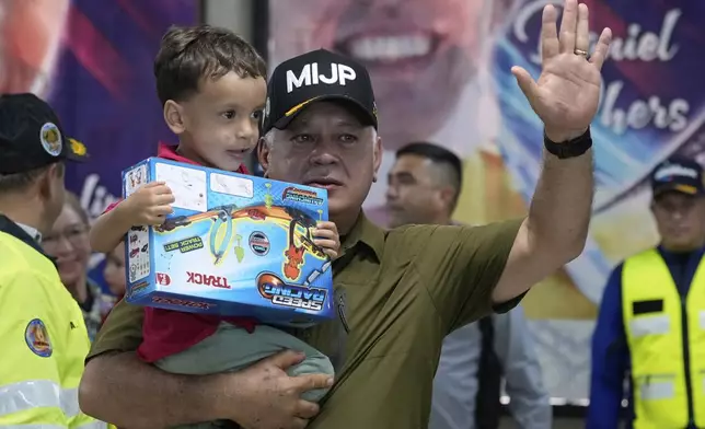 Venezuela's Interior Minister Diosdado Cabello welcomes children of Venezuelan migrants, whose parents were deported separately from the United States, at Simon Bolivar International Airport in Maiquetia, Venezuela, Friday, July 18, 2025. (AP Photo/Ariana Cubillos)