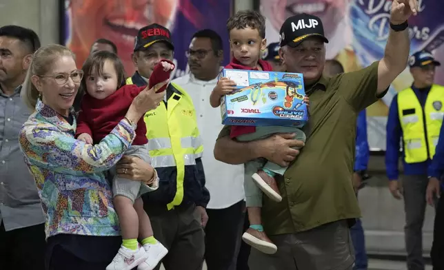Venezuela's Interior Minister Diosdado Cabello, right, and First Lady Cilia Flores welcome children of Venezuelan migrants, whose parents were deported separately from the United States, at Simon Bolivar International Airport in Maiquetia, Venezuela, Friday, July 18, 2025. (AP Photo/Ariana Cubillos)
