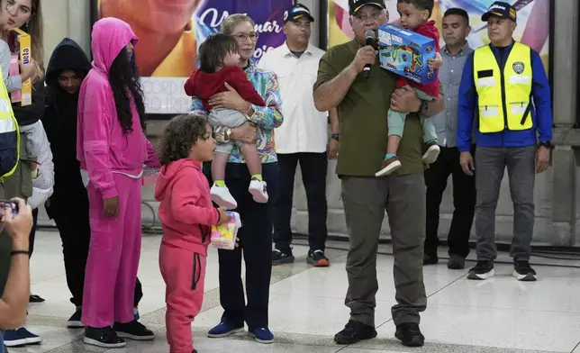 Venezuela's Interior Minister Diosdado Cabello, right, and First Lady Cilia Flores welcome children of Venezuelan migrants, whose parents were deported separately from the United States, at Simon Bolivar International Airport in Maiquetia, Venezuela, Friday, July 18, 2025. (AP Photo/Ariana Cubillos)