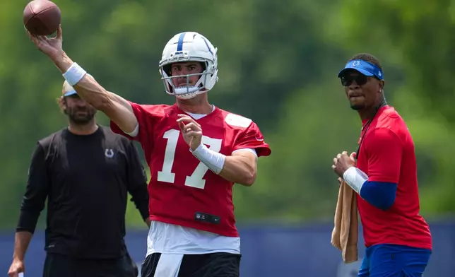 FILE - Indianapolis Colts quarterback Daniel Jones (17) as Anthony Richardson Sr. looks on during practice at NFL football minicamp in Indianapolis, June 10, 2025. (AP Photo/Michael Conroy, File)