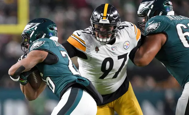 FILE - Pittsburgh Steelers defensive tackle Cameron Heyward (97) attempts to tackle Philadelphia Eagles running back Saquon Barkley (26) during the first half of an NFL football game, Sunday, Dec. 15, 2024, in Philadelphia. (AP Photo/Terrance Williams, File)