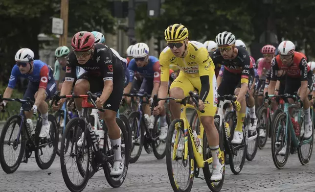 Slovenia's Tadej Pogacar, wearing the overall leader's yellow jersey, rides in the pack during the twenty-first stage of the Tour de France cycling race over 132.3 kilometers (82.1 miles) with start in Mantes-la-Ville and finish on the Champs-Elysees in Paris, France, Sunday, July 27, 2025. (AP Photo/Thibault Camus)