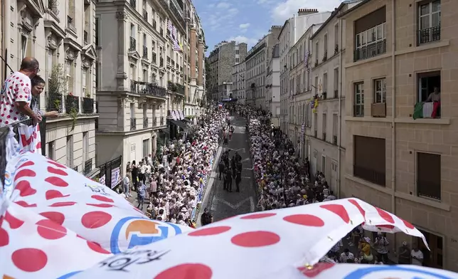 Fan wait for the riders in the street of the Montmartre district before the last stage of the Tour de France cycling race between Mantes-la-Ville and Paris, Sunday, July 27, 2025 in Paris (AP Photo/Laurent Cipriani)