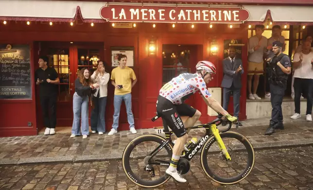 Denmark's Jonas Vingegaard , wearing the best climber's dotted jersey, pedals at the Place de Tertre in the Montmartre district, during the last stage of the Tour de France cycling race between Mantes-la-Ville and Paris, Sunday, July 27, 2025 in Paris (AP Photo/Thomas Padilla)