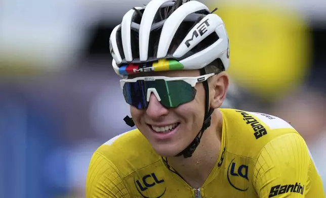 A smiling Slovenia's Tadej Pogacar, wearing the overall leader's yellow jersey, crosses the finish line of the twentieth stage of the Tour de France cycling race over 184.2 kilometers (114.5 miles) with start in Nantua and finish in Pontarlier, France, Saturday, July 26, 2025. (AP Photo/Mosa'ab Elshamy)