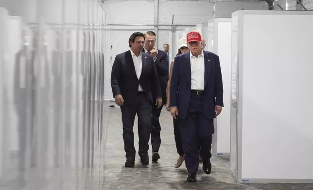President Donald Trump, Gov. Ron DeSantis, R-Fla., Homeland Security Secretary Kristi Noem and others, tour "Alligator Alcatraz," a new migrant detention facility at Dade-Collier Training and Transition facility, Tuesday, July 1, 2025, in Ochopee, Fla. (AP Photo/Evan Vucci)