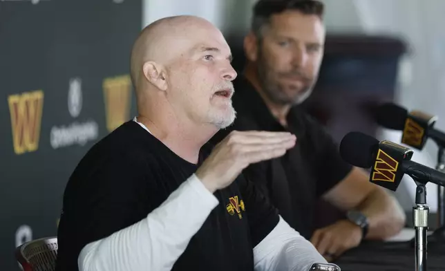 Washington Commanders head coach Dan Quinn, left, speaks as general manager Adam Peters, right, looks on during a news conference at the NFL football team's training camp in Ashburn, Va., Tuesday, July 22, 2025. (AP Photo/Luis M. Alvarez)