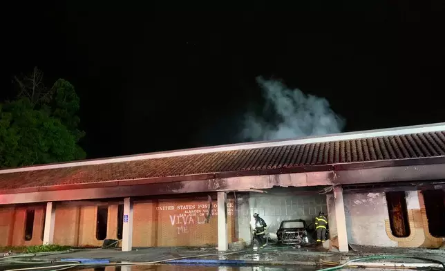 This photo provided by the San Jose Fire Department shows firefighters responding to a fire burning after a car crashed into the Post Office, early Sunday, July 20, 2025, in San Jose, Calif. (San Jose Fire Department via AP)