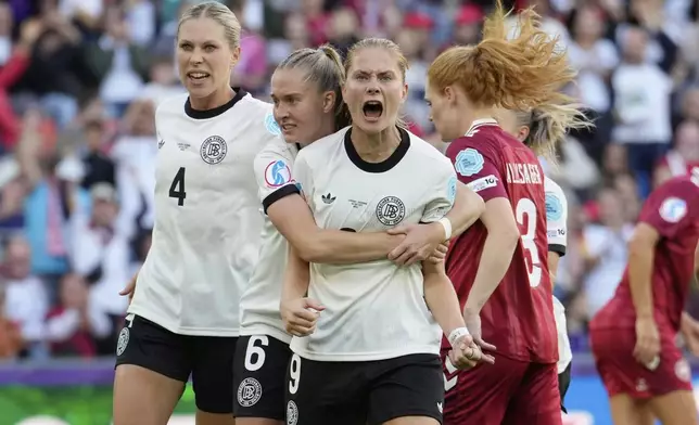 Germany's Sjoeke Nuesken, centre, celebrates with Germany's Rebecca Knaak, left, Germany's Janina Minge after scoring her side's opening goal during the Euro 2025, group C, soccer match between Germany and Denmark at St. Jakob-Park in Basel, Switzerland, Tuesday, July 8, 2025. (AP Photo/Martin Meissner)
