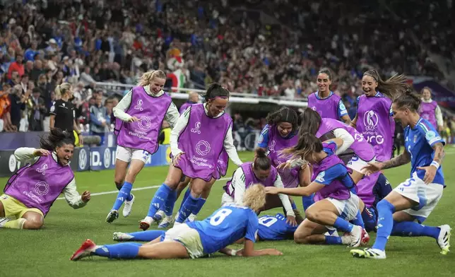 Italy players run celebrating to teammate Cristiana Girelli after she scored the opening goal during the Euro 2025, group B, soccer match between Portugal and Italy at Stade de Geneve in Geneva, Switzerland, Monday, July 7, 2025. (AP Photo/Alessandra Tarantino)