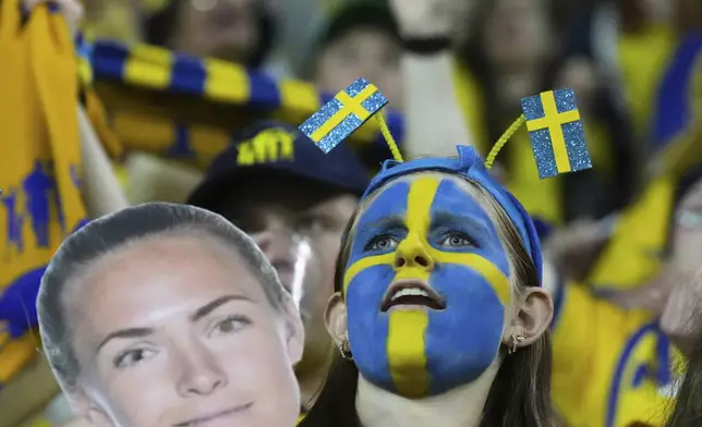 A fan holding a mask of Sweden's Magdalena Eriksson celebrates on the stands at the end of the Euro 2025, group C, soccer match between Poland and Sweden at Allmend Stadion Luzern in Lucerne, Switzerland, Tuesday, July 8, 2025. (AP Photo/Alessandra Tarantino)