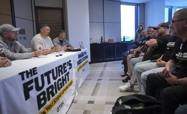 Ukraine's boxer Oleksandr Usyk, second left, meets the Ukrainian war veterans, who are employees of Ukrainian power company DTEK at a hotel in Battersea Park in London, Thursday, July 17, 2025 ahead of the undisputed heavyweight champion boxing fight between Britain's Daniel Dubois and Oleksandr Usyk on Saturday. (AP Photo/Kin Cheung)