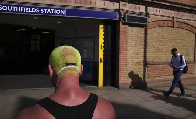 A fan with a haircut like a tennis ball stands outside Southfields tube station near the Wimbledon Tennis Championships in London, Tuesday, July 1, 2025.(AP Photo/Kin Cheung)