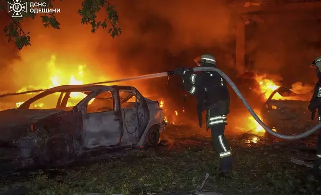 In this photo provided by the Ukrainian Emergency Service, emergency services personnel work to extinguish a fire following a Russian attack in Odesa, Ukraine, Tuesday, July 22, 2025. (Ukrainian Emergency Service via AP)