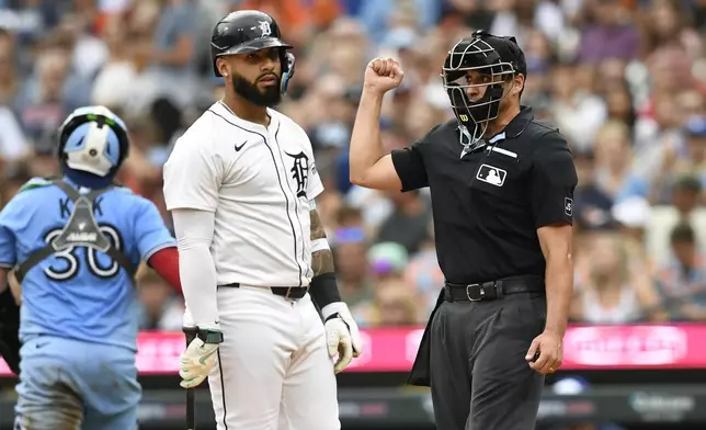 Detroit Tigers' Gleyber Torres, middle, strikes out swinging as home plate umpire Paul Clemons, right, signals the out as Toronto Blue Jays catcher Alejandro Kirk walks away during the third inning of a baseball game, Saturday, July 26, 2025, in Detroit. (AP Photo/Jose Juarez)