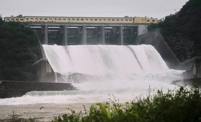 In this photo released by Xinhua News Agency, Water is discharged from Miyun reservoir after continuous rain fall triggers alerts, in Miyun District in north of Beijing on July 27, 2025. (Zhang Chenlin/Xinhua via AP)