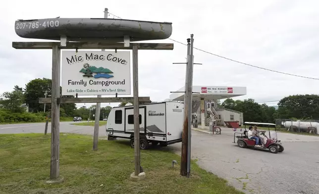 Campers ride a golf cart to the Mic Mac Cove Campground, Wednesday, July 9, 2025, in Union, Maine, where police have used the campground to access Crawford Pond to investigate the murder of a woman last seen paddleboarding on the pond. (AP Photo/Robert F. Bukaty)