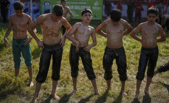 Young wrestlers getting ready to start a round during the 664th annual Historic Kirkpinar Oil Wrestling championship, in Edirne, northwestern Turkey, Sunday, July 6, 2025. (AP Photo/Khalil Hamra)
