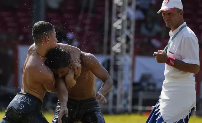 Young wrestlers compete during the 664th annual Historic Kirkpinar Oil Wrestling championship, in Edirne, northwestern Turkey, Sunday, July 6, 2025.(AP Photo/Khalil Hamra)