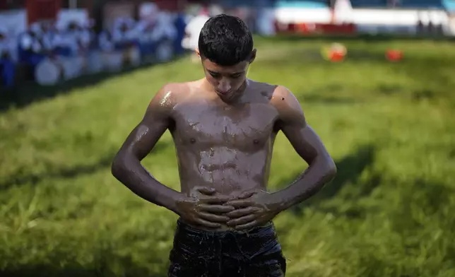 A young wrestler is doused in oil during the 664th annual Historic Kirkpinar Oil Wrestling championship, in Edirne, northwestern Turkey, Sunday, July 6, 2025.(AP Photo/Khalil Hamra)
