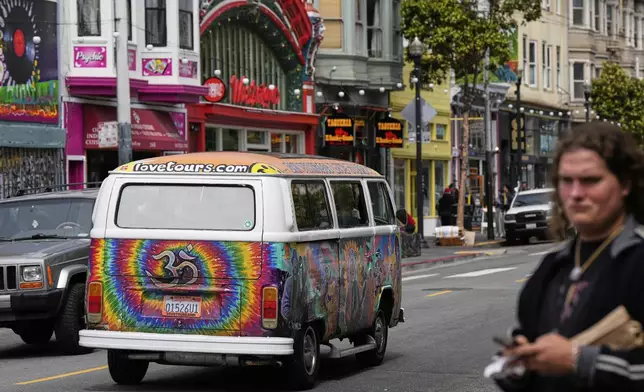 A tour van featuring a painting of musician Jerry Garcia travels through Haight Street in San Francisco, Saturday, July 19, 2025. (AP Photo/Godofredo A. Vasquez)