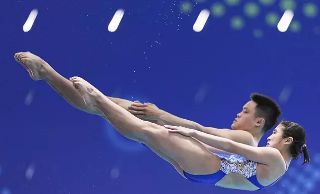 Xie Peiling and Zhu Yongxin of China compete in the mixed 10m synchronised finals at the World Aquatics Championships in Singapore, Sunday, July 27, 2025. (AP Photo/Ng Han Guan)