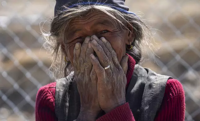 An elderly woman reacts while being photographed at the newly relocated settlement of the abandoned Samjungvillage in the Mustang region, 462 kilometers (288 miles) west of Kathmandu, Nepal, Friday, April 18, 2025. (AP Photo/Niranjan Shrestha)