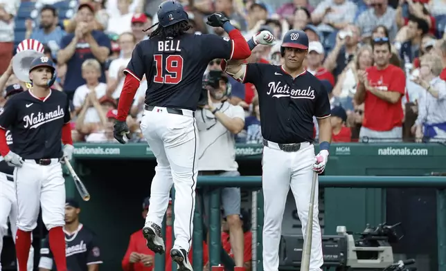 Washington Nationals' Josh Bell (19) celebrates after his solo home run with Nathaniel Lowe, right, during the third inning of a baseball game against the Cincinnati Reds in Washington, Monday, July 21, 2025. (AP Photo/Terrance Williams)