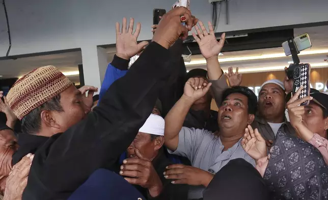 Relatives react as they have a video call with a survivor from a ferry that sank near the resort island of Bali, at Ketapang Port in Bayuwangi, East Java, Indonesia, Thursday, July 3, 2025. (AP Photo/Andur)