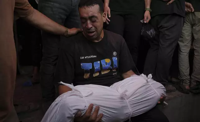 Abdel Hadi Bashir mourns the loss of his two daughters, Sabah and Mira who were killed in an Israeli army airstrike of the Gaza Strip, at the Al-Aqsa Hospital in Deir al-Balah, Wednesday, July 2, 2025. (AP Photo/Abdel Kareem Hana)