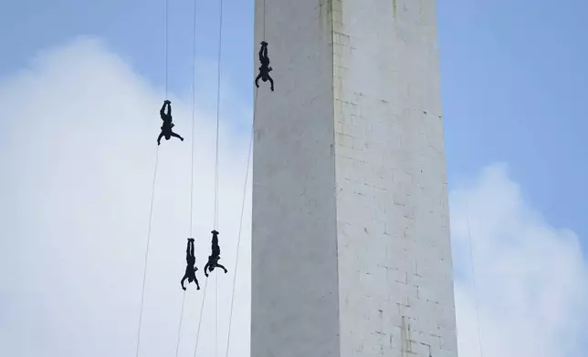 Members of Indonesian paramilitary police unit Mobile Brigade (Brimob) rappel down the National Monument during a show marking the 79th anniversary of Indonesian National Police in Jakarta, Indonesia, Tuesday, July 1, 2025.(AP Photo/Tatan Syuflana)
