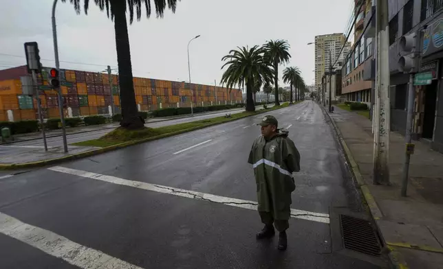A police officer patrols a street near the sea during a precautionary tsunami advisory in Valparaiso, Chile, Wednesday, July 30, 2025, after an earthquake struck off the coast of Russia. (AP Photo/Esteban Felix)