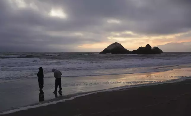 During a tsunami advisory triggered by an underwater earthquake off the coast of Russia, Gaby Lazlo and Daniel Ramirez visit Ocean Beach in San Francisco on Tuesday, July 29, 2025. (Scott Strazzante/San Francisco Chronicle via AP)