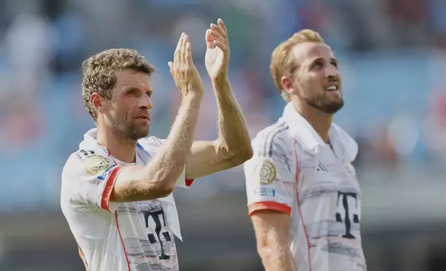 Bayern Munich's Thomas Muller, left, and Harry Kane walk off the pitch after the Club World Cup Group C soccer match between Benfica and Bayern Munich in Charlotte, N.C., Tuesday, June 24, 2025. (AP Photo/Nell Redmond)