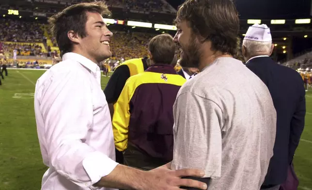FILE - Richard Tillman, left, the brother of former Arizona State player Pat Tillman, greets one of his brother's former teammates Jake Plummer, right, prior to a ceremony retiring Pat's jersey during halftime of the Washington State and Arizona State game, Nov. 13, 2004, in Tempe, Ariz. (AP Photo/Paul Connors, File)