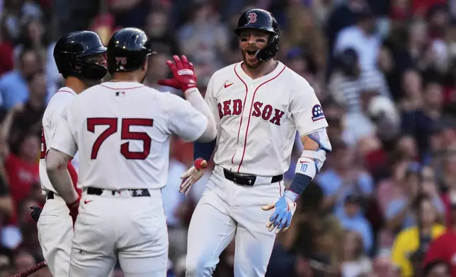 Boston Red Sox's Trevor Story, right, celebrates after his three-run home run during the first inning of a baseball game against the Cincinnati Reds at Fenway Park, Monday, June 30, 2025, in Boston. (AP Photo/Charles Krupa)