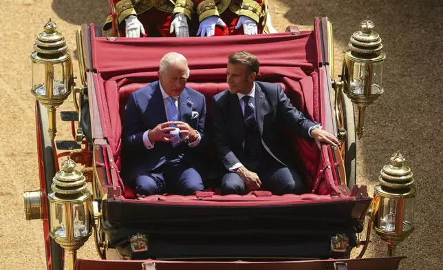 Britain's King Charles III, left, and French President Emmanuel Macron arrive at Windsor Castle in Windsor, England, Tuesday July 8, 2025, on the first day of a three-day state visit to Britain. (Jaimi Joy/Pool via AP)