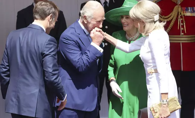 Britain's King Charles III and Queen Camilla welcome France's President Emmanuel Macron, left, and his wife Brigitte Macron, right, in Windsor, England, Tuesday July 8, 2025, on the first day of a three-day state visit to Britain. (Chris Jackson/Pool via AP)