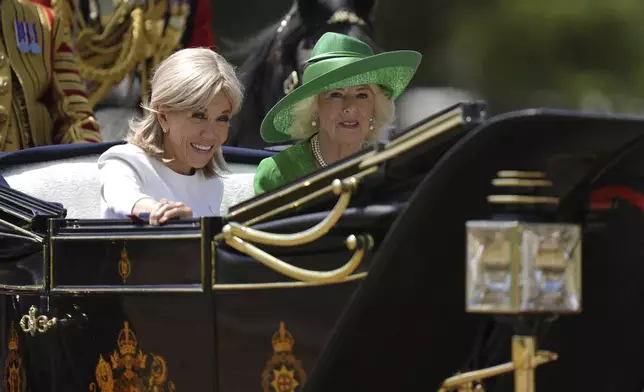 Britain's Queen Camilla and Brigitte Macron, left, travel in a Semi-State Landau on a state drive to Windsor Castle in Windsor, England, Tuesday July 8, 2025, on the first day of a three-day state visit to Britain. (Andrew Matthews/Pool via AP)