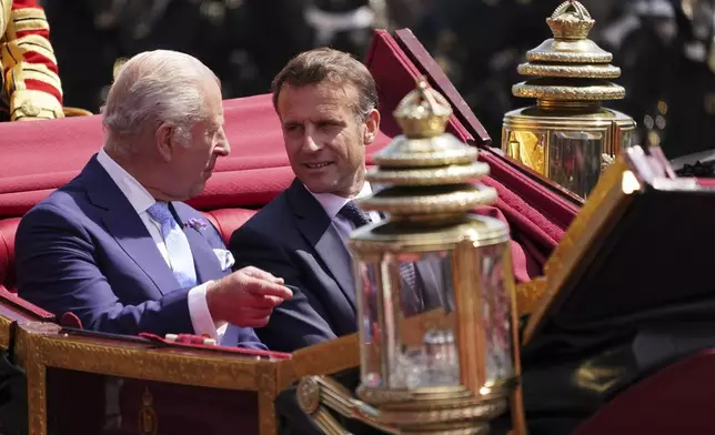 Britain's King Charles III and French President Emmanuel Macron travel in a 1902 State Landau carriage through Windsor, England, Tuesday, July 8, 2025.(AP Photo/Alberto Pezzali, Pool)