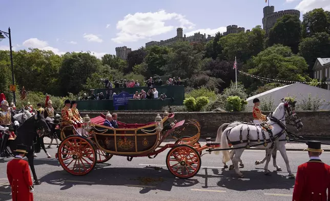 Britain's King Charles III and French President Emmanuel Macron travel in a 1902 State Landau carriage through Windsor, England, Tuesday, July 8, 2025.(AP Photo/Alberto Pezzali, Pool)