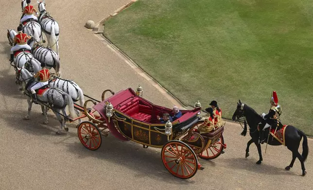 Britain's King Charles III, right, and French President Emmanuel Macron arrive at Windsor Castle in Windsor, England, Tuesday July 8, 2025, on the first day of a three-day state visit to Britain. (Jaimi Joy/Pool via AP)